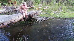 Naked on a log and in the stream. Thumb